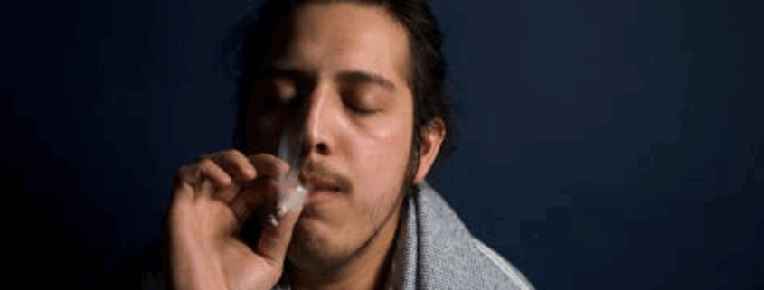 A gay person smoking weed.