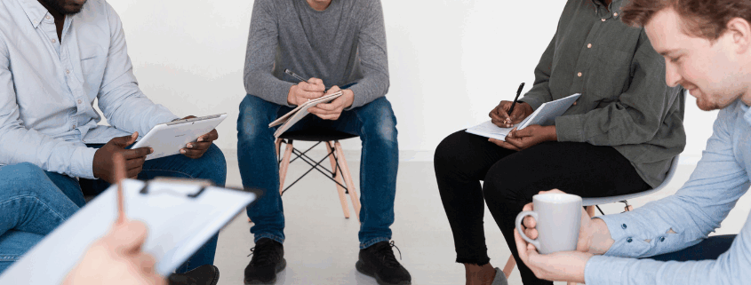 LGBTQ individuals in a support group circle during addiction treatment and recovery session.