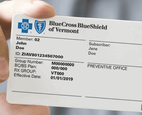 An image of a hand holding Blue Cross Blue Shield insurance card.