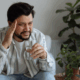 A bisexual person suffering from a headache from alcohol withdrawal sypmtoms.