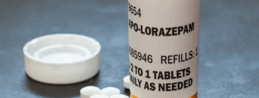 Prescription bottle labeled Lorazepam with scattered tablets.