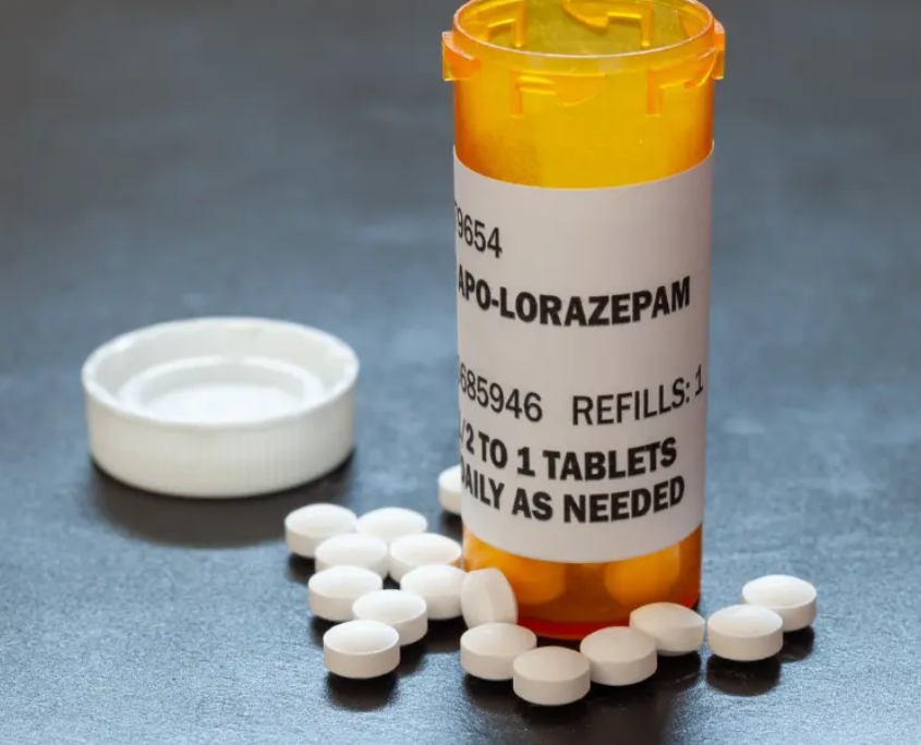 Prescription bottle labeled Lorazepam with scattered tablets.