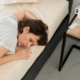 A lesbian woman lying in bed experiencing fatigue and emotional distress.