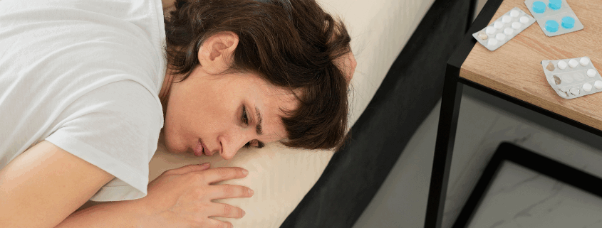 A lesbian woman lying in bed experiencing fatigue and emotional distress.