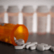 White tranquilizer tablets coming out of a medical bottle.