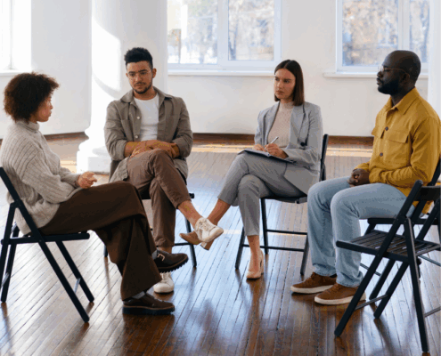 A group of LGBTQ individuals in a sober support group therapy.