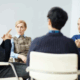 A small group of people at a beginners NA meeting all looking at the person speaking.