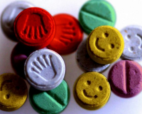 MDA and MDMA tablets of different colors, representing the effects of the drug on someone's mood and emotion