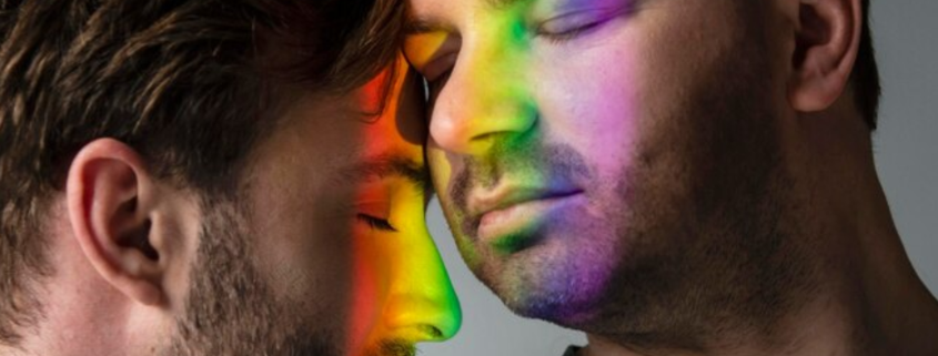 Two men embracing peacefully, with a rainbow light reflection on their faces, symbolizing the benefits of being drug-free.