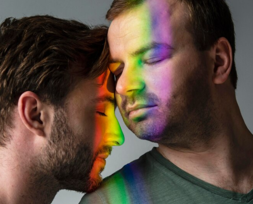 Two men embracing peacefully, with a rainbow light reflection on their faces, symbolizing the benefits of being drug-free.