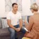 A gay man and a female therapist during an individual therapy for CPTSD.